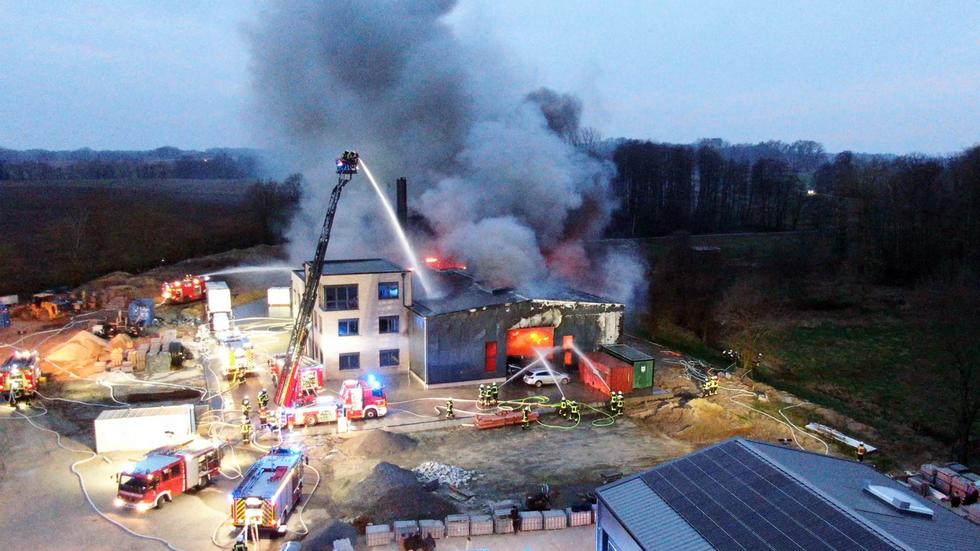 Brand: Einsatzkräfte der Feuerwehr löschen den Großbrand einer Gewerbehalle in Alfhausen.