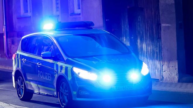 Hameln-Pyrmont: Ein Fahrzeug der Polizei fährt mit Blaulicht am Abend durch eine enge Straße.