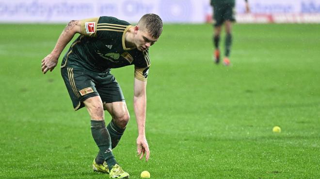 Bundesliga: Andras Schäfer von Union hebt einen Tennisball auf, der aus dem Block der Union-Fans geworfen wurde.