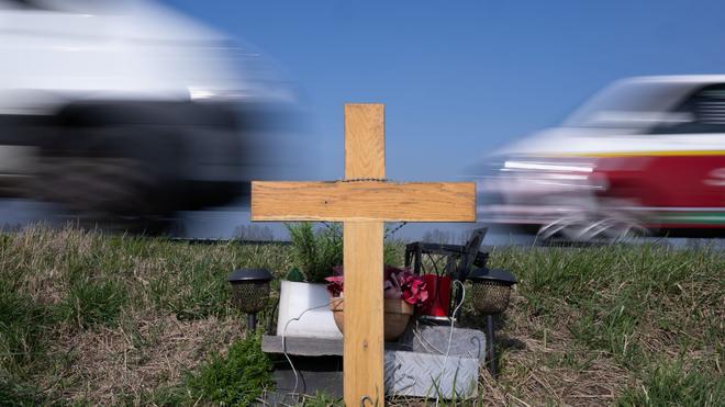 Verkehr: Ein Holzkreuz erinnert an einer Straße an das Opfer eines Verkehrsunfalls.