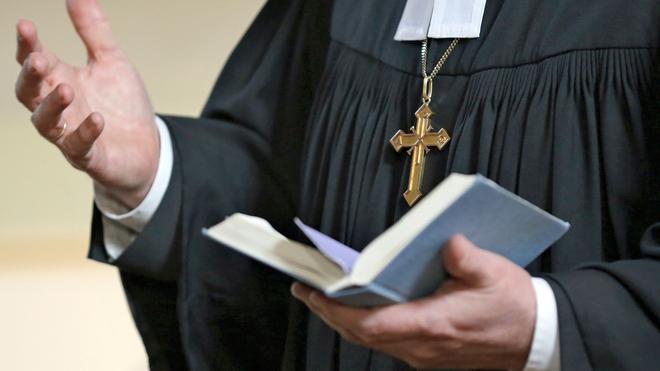 Brauchtum: Ein Geistlicher der Evangelischen Landeskirche Sachsen-Anhalts hält ein Gesangbuch in der Hand.