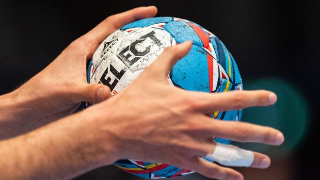 Handbal: Een handballer heeft de wedstrijdbal in zijn handen.