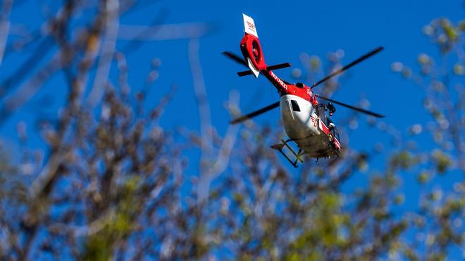 Ondoorgrondelijk: een helikopter van de DRF vliegt door de lucht boven een bos.