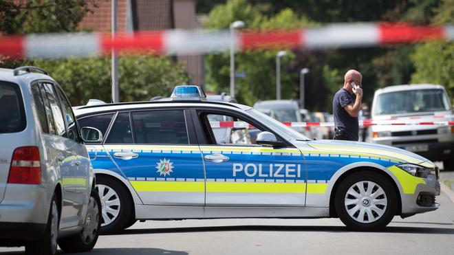Karlsruhe: Polizeiautos und Beamte stehen auf einer gesperrten Straße.