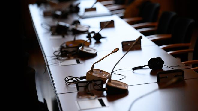 Prozesse: Mikrofone und Kopfhörer auf einem Tisch in einem Gerichtssaal.