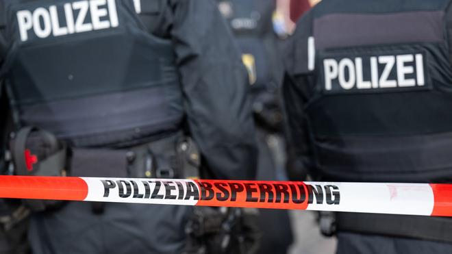 Kriminalität: Polizisten stehen hinter einer Streifenlinie der Polizei.