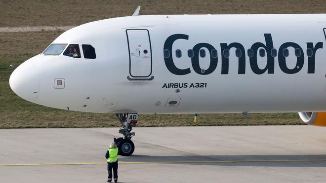 Tourismus: Der Pilot einer Condor-Maschine mit Ziel Teneriffa winkt dem Bodenpersonal vor dem Start vom Flughafen Leipzig/Halle zu.