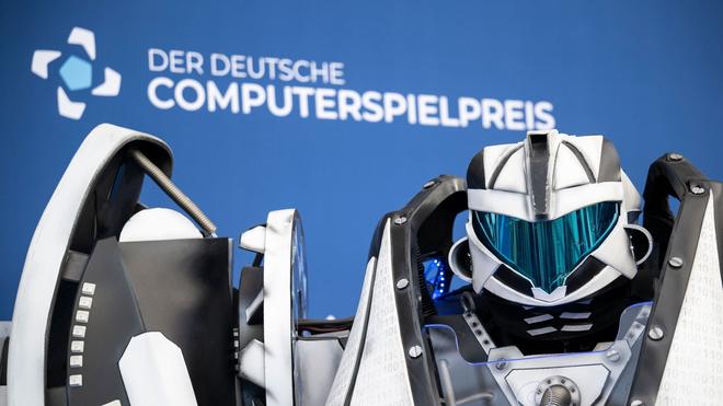 Videospiel: Der Gamescom Bot steht vor der Fotowand mit Schriftzug «Der Deutsche Computerspielpreis».