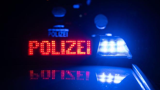 Polizeieinsatz: Zwei Polizisten stehen vor einem Streifenwagen.