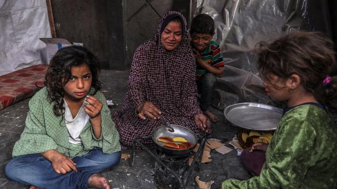 Krieg in Nahost: Eine palästinensische Familie kocht in einem behelfsmäßigen Zelt in Rafah.