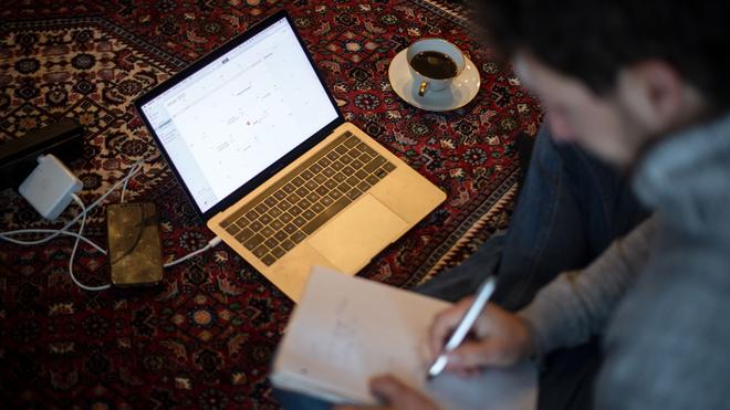 Statistik: Ein Mann sitzt im Homeoffice mit Laptop auf dem Teppich und arbeitet.