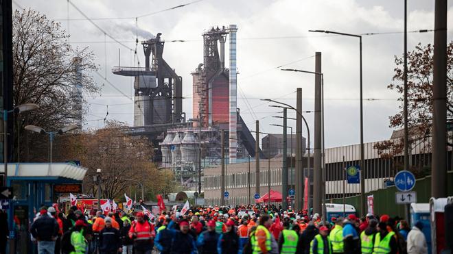 Industrie: Teilnehmer einer Kundgebung im Rahmen des bundesweiten Aktionstags für einen Brückenstrompreis laufen vor den Hochhöfen des Werks von Thyssenkrupp.