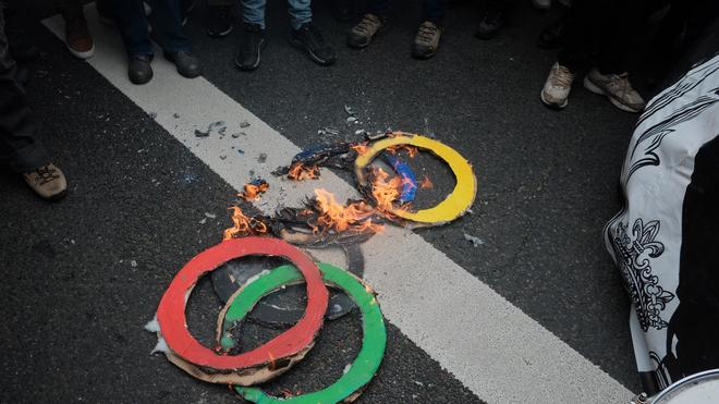 Fotografie: Mit brennenden Ringen machen einige Pariser am 1. Mai darauf aufmerksam, was sie wirklich von der Ausrichtung der Olympischen Spiele in ihrer Stadt halten.