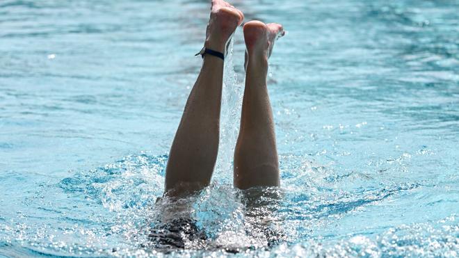 Wetter: Ein Schwimmer macht eine Wendung im Becken eines Schwimmbades.