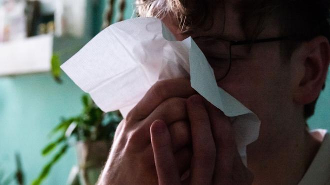 Gesundheit: Ein Mann putzt sich mit einem Taschentuch die Nase.