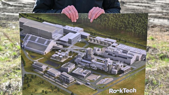 Spree-Neiße: Ein Bild mit einer Computersimulation der fertigen Fabrik zeigt ein Mitarbeiter von Rock Tech auf dem Baugelände für eine Lithiumfabrik des kanadischen Unternehmens.