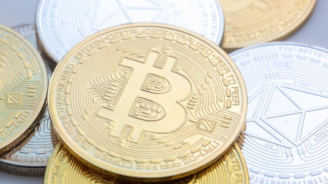 Kriminalität: Bitcoin (M) und Ethereum-Münzen sind auf einem Tisch angeordnet.