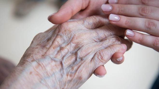 Soziales: Eine Krankenschwester hält die Hand einer Bewohnerin im Seniorenzentrum St. Elisabeth.