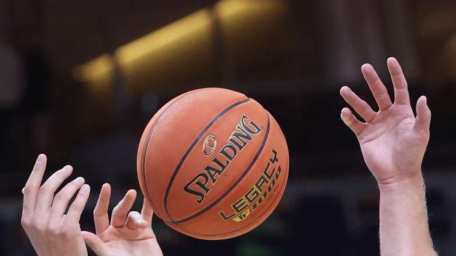 Basketball-Bundesliga: Spieler greifen nach einem Basketball.