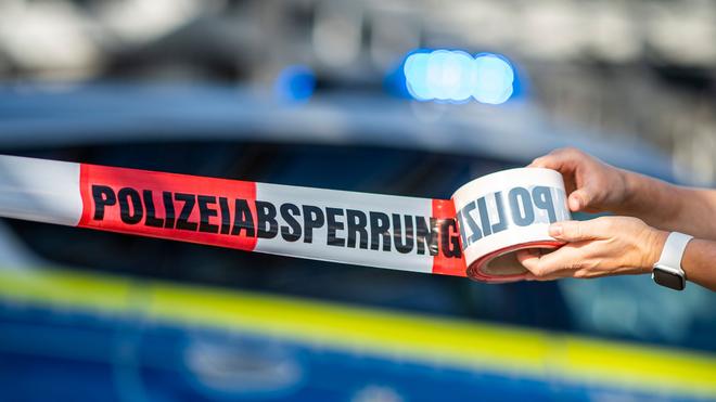 Verkehr: Vor einem Polizeiauto wird ein Absperrband ausgerollt.