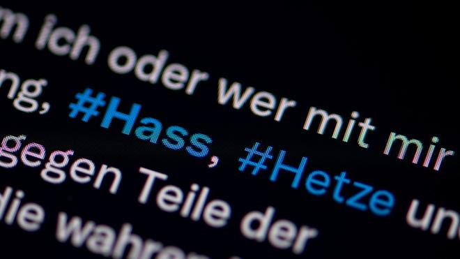 Hasskommentare im Internet: Auf dem Bildschirm eines Smartphones sieht man die Hashtags Hass und Hetze in einem Twitter-Post.