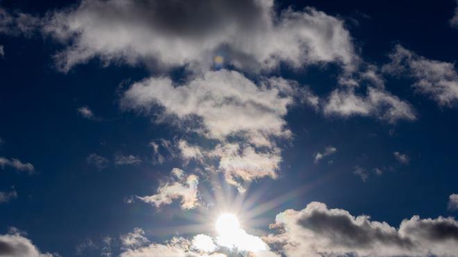 Wetter: Die Sonne scheint durch Wolken.