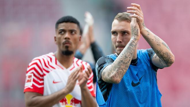 Fußball: Die Leipziger Benjamin Henrichs (l) und David Raum reagieren auf dem Spielfeld.