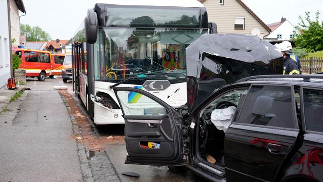 Verkehrsunfall: Ein Auto und ein Bus sind nach einem Unfall unterwegs.