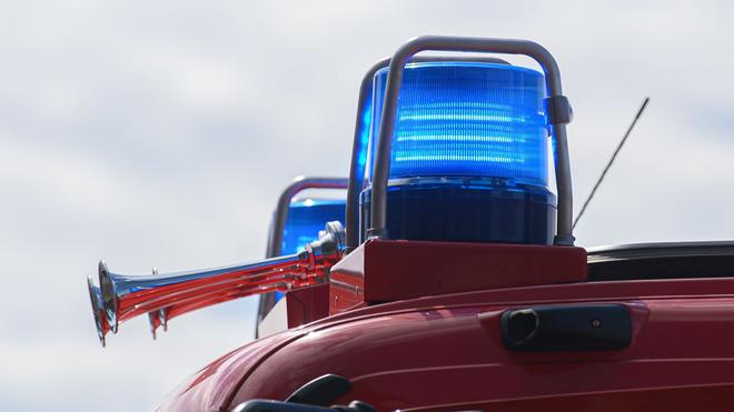 Brände: Blaue Lichter leuchten auf dem Dach eines Feuerwehrfahrzeugs.