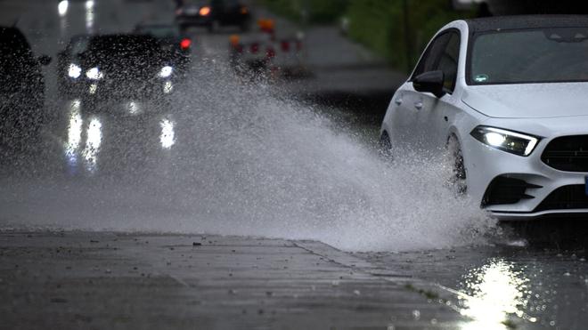 Wetter: Ein Auto fährt durch ein großes Wasserbecken.