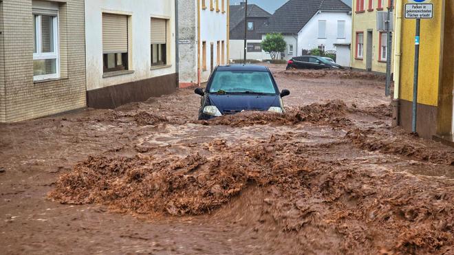 Wetter: Ein Auto bahnt sich seinen Weg durch die Wassermassen.