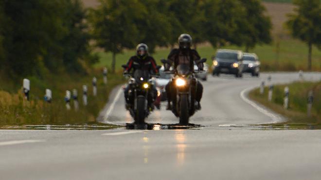 Verkehr: Zwei Biker fahren auf einer Landstraße.