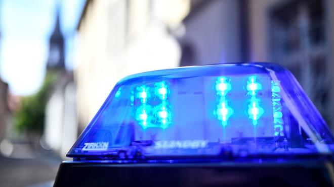 Kriminalität: Ein Polizeiauto mit Blaulicht ist vor einem Gebäude geparkt.