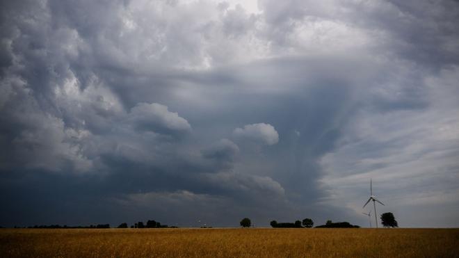 Wetter: Dunkle Wolken ziehen über einem Windrad in der Region Hannover.