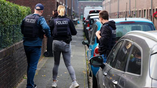 Kriminalität: Polizisten stehen in einer Straße vor einem Haus in Duisburg, das derzeit durchsucht wird.