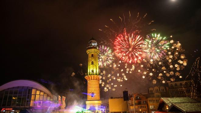 Showtime in Warnemünde: Zahlreiche Menschen haben am Neujahrstag das traditionelle Warnemünder Turmleuchten an der Strandpromenade des Ostseebades verfolgt.