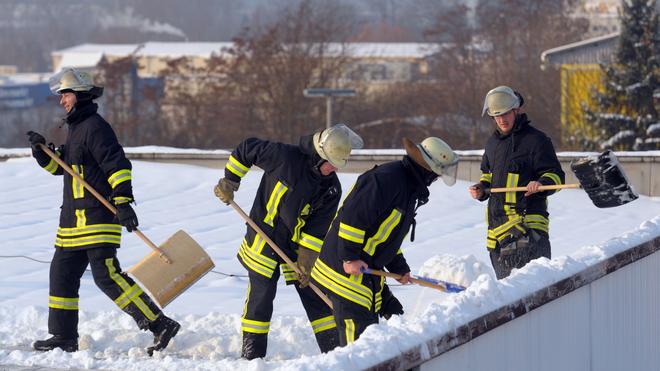 Schwerer Schnee: Ein Foto aus dem Jahr 2010 aus Gera in Thüringen: Feuerwehrleute beseitigen Schnee vom Dach einer Turnhalle. So eine Unterstützung hätten die Menschen in Goch (NRW) nun wohl auch gern. (Archivbild)