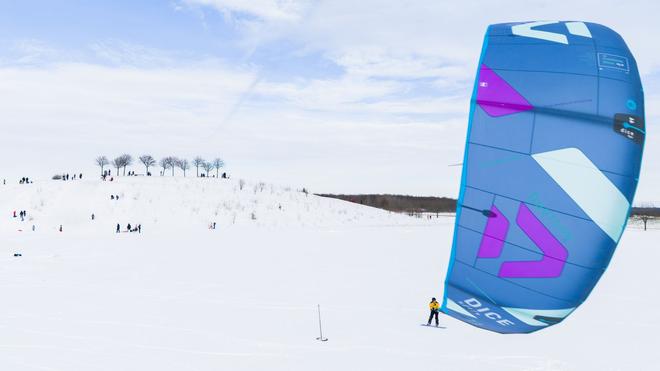 Winterwetter: Ein Kite-Surfer gleitet am Kronsberg mit seinem Board über den Schnee.