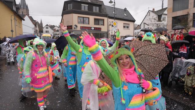 Karneval: Narren feiern Weiberfastnacht mit Schirm und Regenjacke