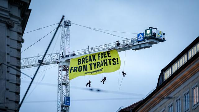 Sicherheitskonferenz: Kletterer entrollen Protest-Transparent an Kran in München