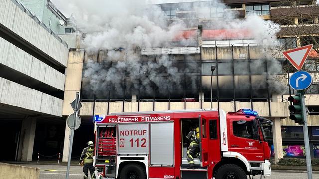 Ermittlungen laufen: Feuerwehr mit Atemschutz löscht brennendes Auto im Parkhaus