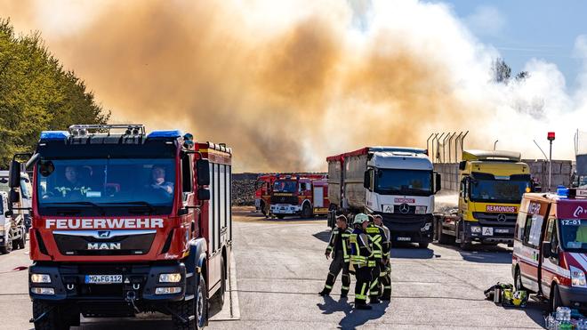 Blaulicht: Feuerwehrleute löschen die Flammen auf der Deponie in Weißenfels.