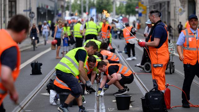 Leipzig residents help clear bitumen from tram tracks after heatwave disruption