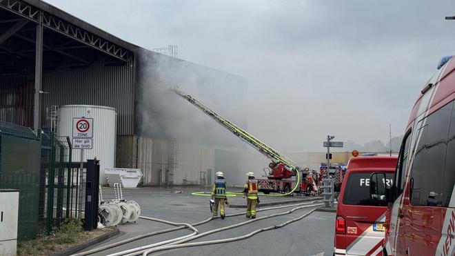 Großeinsatz der Feuerwehr: Feuerwehrleute im Einsatz beim Duisburger Recyclinghof.