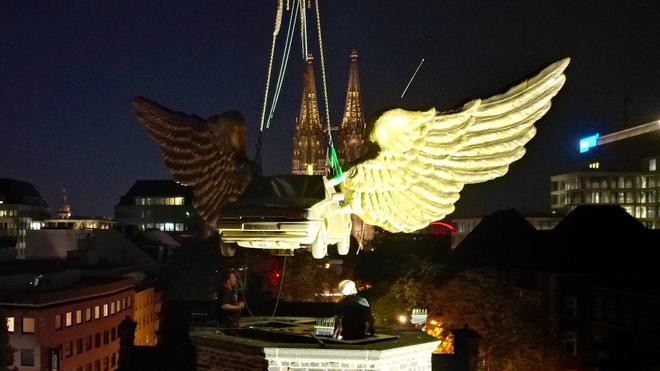Demontage eines Kunstwerks: Das goldene Auto wird mit einem Kran von dem Turm gehoben.