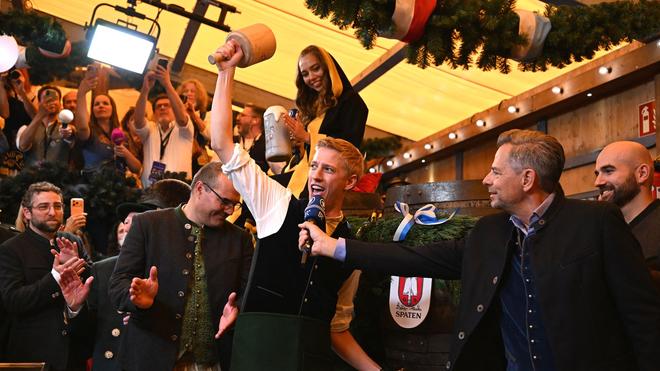 Fotografie: Oktoberfest 2026: ein Mann mit Gamsbart steht am ersten Wiesn Tag vor dem Riesenrad.