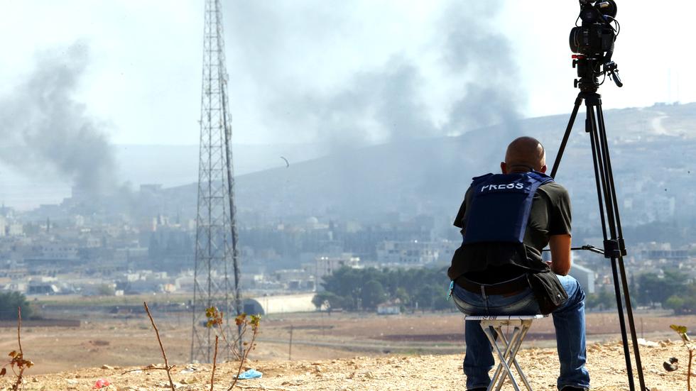 Terrorwarnungen: Ein Kameramann beobachtet an der türkisch-syrischen Grenze die Kämpfe im nahe gelegenen Kobane.