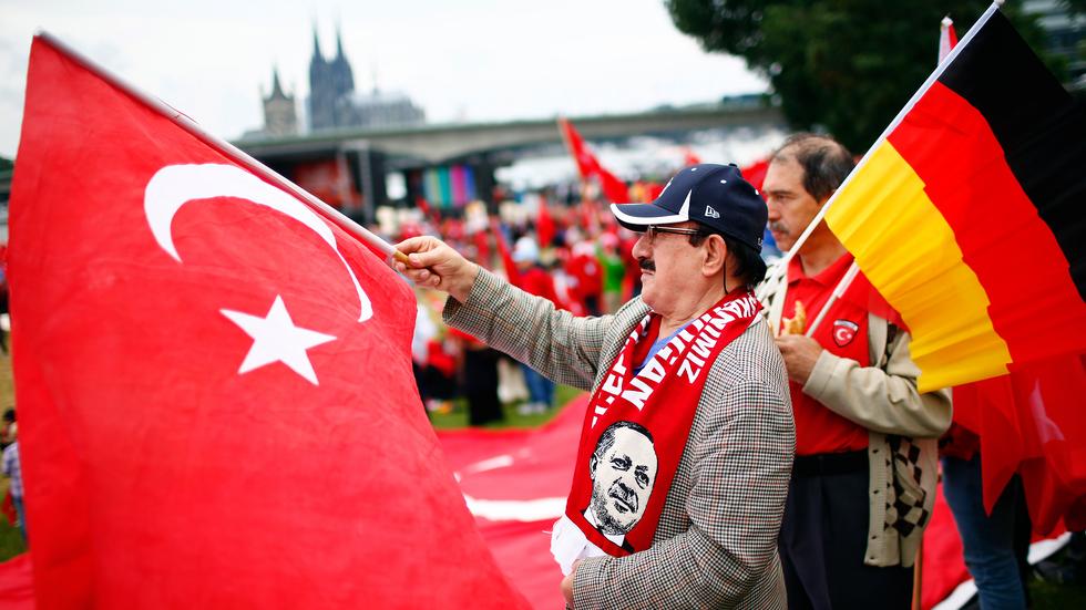 Unterstützer Erdoğans schwenken bei der Demonstration in Köln die türkische Flagge. 
