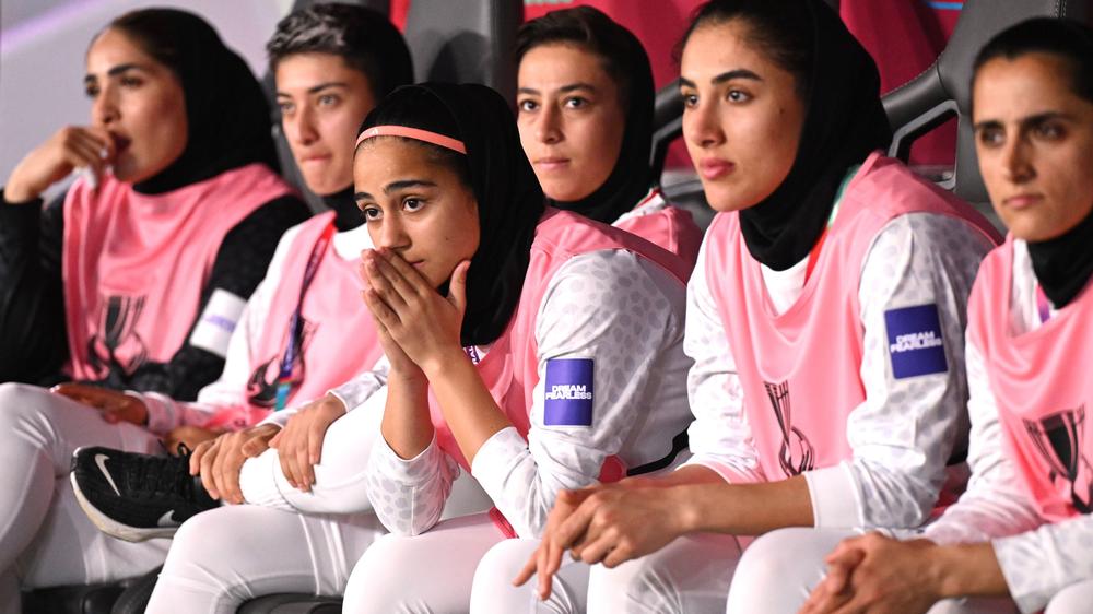  Iranische Spielerinnen verfolgen das Spiel zwischen Südkorea und dem Iran beim Asien-Cup. Bei diesem Spiel hatten die Spielerinnen während der Nationalhymne geschwiegen – im Iran wurde das als Zeichen gegen die Führung in Teheran gewertet.