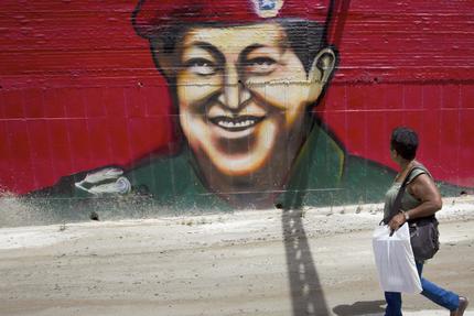Eine Frau vor einem Chávez-Graffito in Caracas